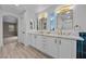 Elegant bathroom featuring a double sink vanity with white cabinets, marble countertop, and modern gold fixtures at 575 Dusty Palms Ln, Henderson, NV 89052