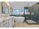 Elegant bathroom features a soaking tub, glass shower, and double vanity with gold hardware at 575 Dusty Palms Ln, Henderson, NV 89052