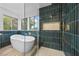 Modern bathroom featuring a soaking tub, walk-in shower with designer tile, and natural light from large windows at 575 Dusty Palms Ln, Henderson, NV 89052