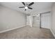 Spacious bedroom with plush carpeting, ceiling fan, and a mirrored closet providing ample storage space at 575 Dusty Palms Ln, Henderson, NV 89052