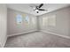 Bedroom featuring neutral walls, plush carpeting, three arched windows, and a large window for natural light at 575 Dusty Palms Ln, Henderson, NV 89052
