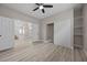 Spacious bedroom featuring light hard wood floors, ceiling fan, walk in closet, and a view of the stairs at 575 Dusty Palms Ln, Henderson, NV 89052