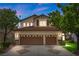 Inviting two-story home with a three-car garage, manicured lawn, and mature trees under a twilight sky at 575 Dusty Palms Ln, Henderson, NV 89052