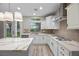 Bright, modern kitchen featuring white cabinets, quartz countertops, gas range, and stainless steel appliances at 575 Dusty Palms Ln, Henderson, NV 89052