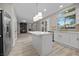 Kitchen with white cabinets, stainless steel fridge, quartz island, and an open view to the living area at 575 Dusty Palms Ln, Henderson, NV 89052