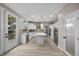 Open concept kitchen features white cabinets, quartz island, stainless appliances, and wood-look flooring at 575 Dusty Palms Ln, Henderson, NV 89052