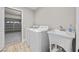 Bright laundry room featuring a washer, dryer, utility sink and easy access to garage at 575 Dusty Palms Ln, Henderson, NV 89052