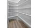 Spacious walk-in pantry with ample shelving for optimal storage and wood-look flooring at 575 Dusty Palms Ln, Henderson, NV 89052