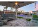 Covered patio with seating area, pool, and lush landscaping for relaxation and entertainment at 5865 Alice Landing Ct, Las Vegas, NV 89149