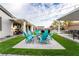 Inviting backyard with fire pit, synthetic grass, pavers, string lights and a view of the pool at 5865 Alice Landing Ct, Las Vegas, NV 89149