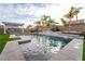 Backyard pool featuring built in jacuzzi, lush landscaping, waterfall features, and shaded seating at 5865 Alice Landing Ct, Las Vegas, NV 89149