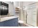 Well-lit bathroom with a vanity, granite countertop, and a glass-enclosed shower at 5865 Alice Landing Ct, Las Vegas, NV 89149