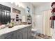 Well-lit bathroom showcasing gray cabinetry, granite countertops, coordinated towels, and a shower-tub combination at 5865 Alice Landing Ct, Las Vegas, NV 89149