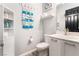 Charming half bathroom featuring beach themed decor, a sink with cabinet and shelving at 5865 Alice Landing Ct, Las Vegas, NV 89149
