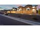Charming single-story home showcasing stone detailing, well-kept landscaping, and illuminated walkway at 5865 Alice Landing Ct, Las Vegas, NV 89149