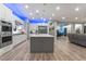 A modern kitchen with an island, stainless steel appliances, and views into the living room at 5865 Alice Landing Ct, Las Vegas, NV 89149