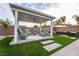 Comfortable backyard pergola featuring ample seating, a ceiling fan, shade, and lush green surroundings at 5865 Alice Landing Ct, Las Vegas, NV 89149