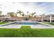 Beautiful pool area featuring palm trees, a manicured lawn, stylish patio furniture, and refreshing water features at 5865 Alice Landing Ct, Las Vegas, NV 89149