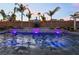 Inviting pool with palm trees, ambient lighting, and a charming waterfall feature, perfect for backyard getaways at 5865 Alice Landing Ct, Las Vegas, NV 89149