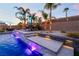 Spectacular pool with waterfall features, palm trees, and ambient lighting creating a private backyard retreat at 5865 Alice Landing Ct, Las Vegas, NV 89149