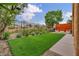 Beautiful backyard featuring artificial turf, manicured landscaping, and outdoor dining area at 617 Apricot Rose Pl, Las Vegas, NV 89138