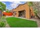 A manicured backyard features a patio, artificial turf and a modern wooden fence at 617 Apricot Rose Pl, Las Vegas, NV 89138