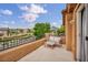 Relaxing balcony features patio furniture, offering a scenic neighborhood view under a bright blue sky at 617 Apricot Rose Pl, Las Vegas, NV 89138