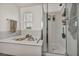 Bathroom showcasing a soaking tub and glass-enclosed shower with built-in shelving at 617 Apricot Rose Pl, Las Vegas, NV 89138