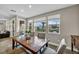 Spacious dining room featuring a rustic wooden table and chairs, with large windows overlooking the backyard at 617 Apricot Rose Pl, Las Vegas, NV 89138