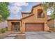 Home featuring a red tile roof, desert landscaping, a covered porch, and a two-car garage at 617 Apricot Rose Pl, Las Vegas, NV 89138