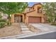 Inviting stucco home with a tiled roof, balcony, attached garage, desert landscaping, and an attractive front entrance at 617 Apricot Rose Pl, Las Vegas, NV 89138