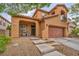Charming two-story home with a gated entrance, front porch, attached garage, and desert landscaping at 617 Apricot Rose Pl, Las Vegas, NV 89138