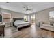 Spacious main bedroom with a king bed, ceiling fan, wood floors, and a private balcony at 617 Apricot Rose Pl, Las Vegas, NV 89138