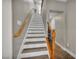 Staircase with wood railing and decorative iron spindles leading to the upper level, carpeted treads at 617 Apricot Rose Pl, Las Vegas, NV 89138
