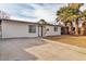 Charming home featuring a clean white exterior, dark window trim and desert landscaping with mature palm trees at 617 Stanford St, Las Vegas, NV 89107