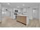 Eat-in kitchen with white cabinets, an island, stainless steel appliances, and hardwood floors open to other rooms at 617 Stanford St, Las Vegas, NV 89107