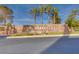 Elegant stone community sign with 'Marseilles' lettering, landscaping, and palm trees at 69 Bellissima Lago Ct, Henderson, NV 89011
