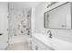 Bathroom with marble tiled shower and tub, white cabinets, and modern mirror at 700 Carnegie St # 3913, Henderson, NV 89052