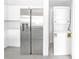 Modern kitchen with stainless steel refrigerator, white cabinets, and adjacent laundry closet at 700 Carnegie St # 3913, Henderson, NV 89052