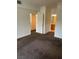 A spacious bedroom with neutral walls and dark brown carpet, showcasing the entrance to the bathroom at 7131 S Durango Dr # 104, Las Vegas, NV 89113