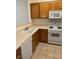 Kitchen with white appliances, wood cabinets, and tile flooring at 7131 S Durango Dr # 104, Las Vegas, NV 89113