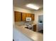 Kitchen featuring wood cabinets, white appliances, and view into laundry area at 7131 S Durango Dr # 104, Las Vegas, NV 89113