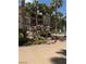A decorative water feature with palm trees and colorful landscaping at 7131 S Durango Dr # 104, Las Vegas, NV 89113