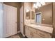Bathroom with granite countertops, white cabinets, vanity sink, and a large mirror at 7189 S Durango Dr # 203, Las Vegas, NV 89113