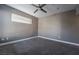 This bedroom features neutral walls, carpet floors, a ceiling fan and a window with blinds at 7189 S Durango Dr # 203, Las Vegas, NV 89113