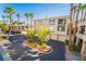 View of a condo complex featuring lush landscaping, palm trees, and well-maintained buildings at 7189 S Durango Dr # 203, Las Vegas, NV 89113