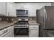 Efficient kitchen with white cabinets, granite countertops, and modern stainless steel appliances at 7189 S Durango Dr # 203, Las Vegas, NV 89113