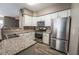Functional kitchen featuring white cabinets, granite counters, and stainless steel appliances at 7189 S Durango Dr # 203, Las Vegas, NV 89113