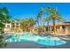 A community pool with lounge chairs and lush palm trees at 7189 S Durango Dr # 203, Las Vegas, NV 89113