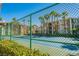 Well-maintained tennis court surrounded by a green fence with palm trees, adjacent to a beautiful building at 7189 S Durango Dr # 203, Las Vegas, NV 89113